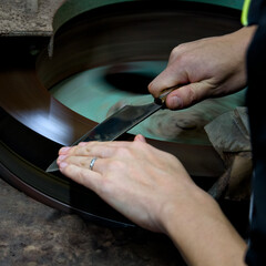 作業場で包丁を研ぐ女性の手