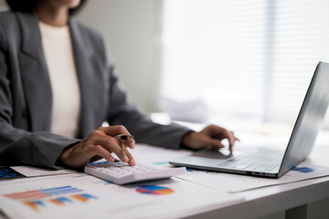 Businesswoman calculating finances using laptop and calculator