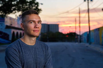 Handsome young man in a downtown urban setting at sunset