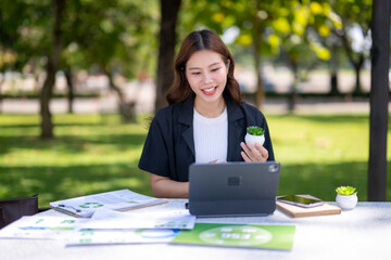 Asian businesswoman showing small plant during video call