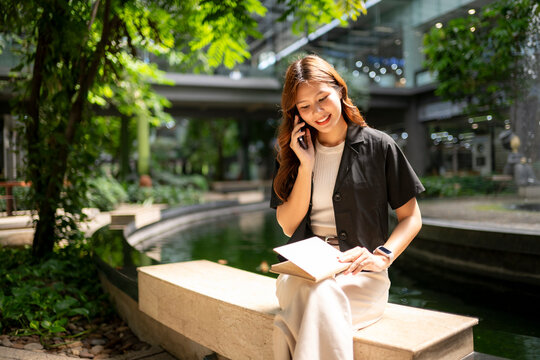 Asian woman balancing work and life in urban park