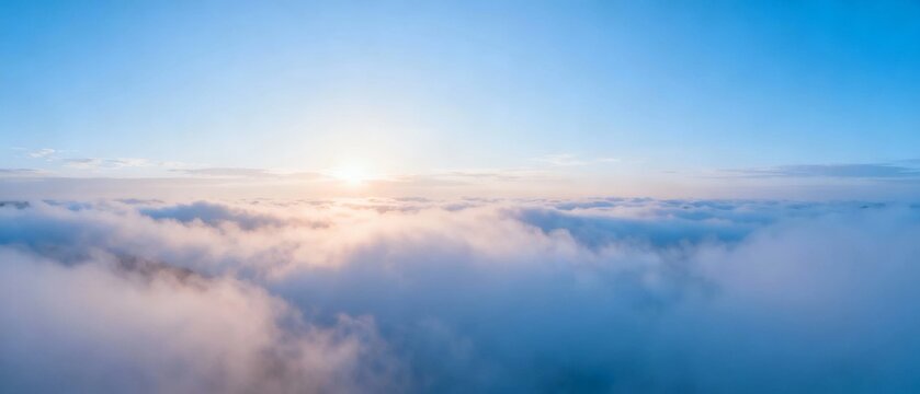 Sunrise above a sea of clouds with soft golden light illuminating the sky