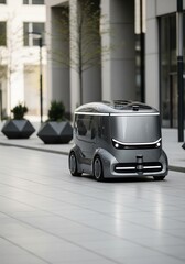 Sleek gray autonomous delivery or shuttle vehicle moving on a modern plaza sidewalk
