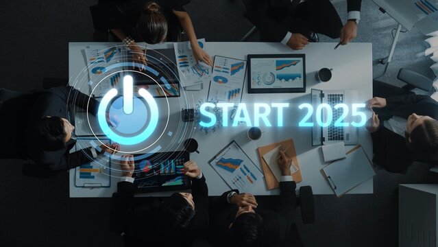 A dynamic business meeting scene featuring a diverse team collaborating on strategic planning for 2025, utilizing data visualization and digital presentations. Raster - Powered by Adobe