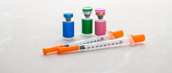 Single Use Syringes Next to Small Glass Vials