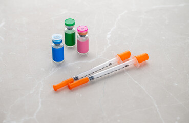Single Use Syringes Next to Small Glass Vials