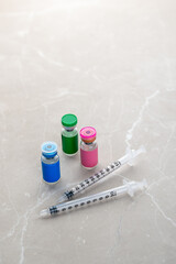 Single Use Syringes Next to Small Glass Vials