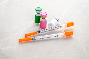 Single Use Syringes Next to Small Glass Vials