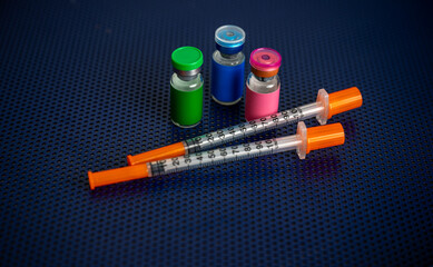 Single Use Syringes Next to Small Glass Vials
