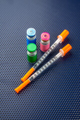 Single Use Syringes Next to Small Glass Vials