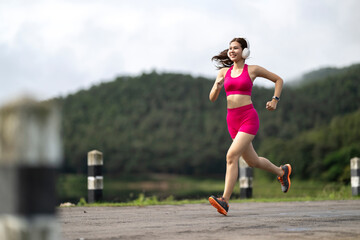 Woman running outdoors listening music with headphones