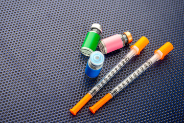 Single Use Syringes Next to Small Glass Vials
