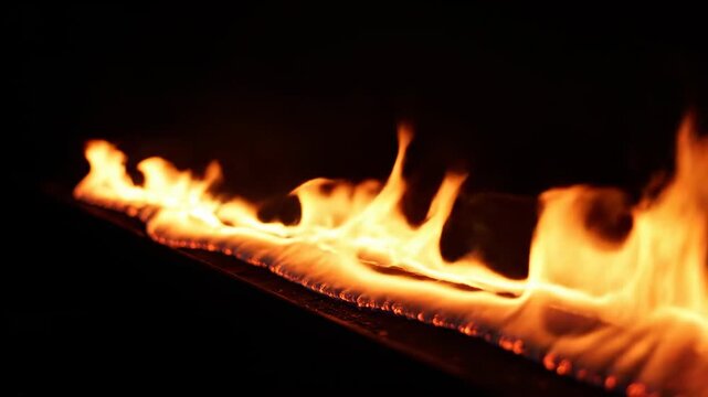 Burning wood in the dark with bright flames.