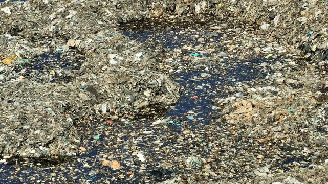 Aerial perspective of accumulated waste representing pollution severity, environmental degradation, consumer overuse, inefficient waste management, and the call for sustainability awareness.
