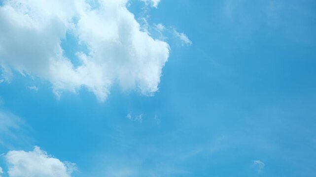 Sky time-lapse video showing soft white clouds drifting across a blue sky, creating an airy, uplifting atmosphere filled with gentle motion and the calming rhythm of open, sunlit skies. Time lapse.
