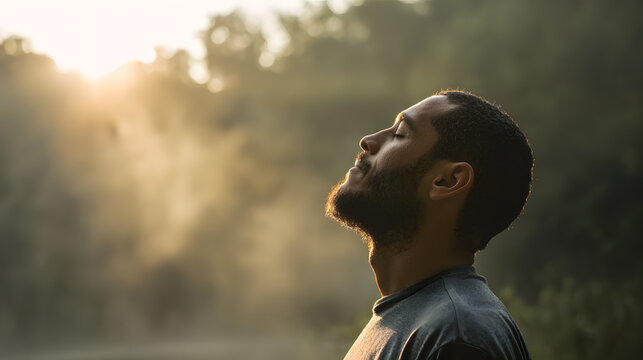 Profile of a peaceful man with a beard, eyes closed, enjoying a moment of calm and introspection amidst the golden light of a misty morning outdoors. - Powered by Adobe
