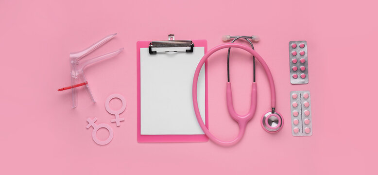 Clipboard with stethoscope, symbols of woman, pills and gynecological speculum on pink background