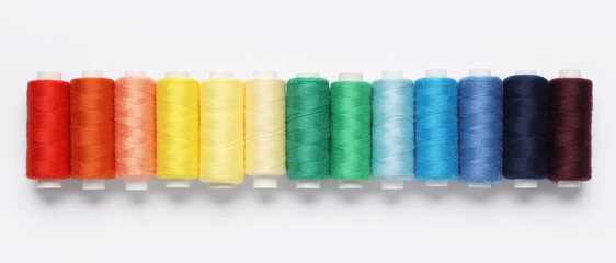 Set of different thread spools on white background