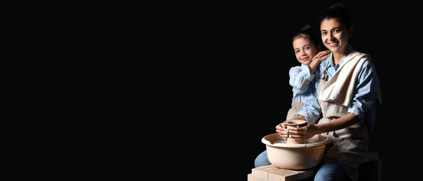 Little girl with her mother making ceramic pot on dark background