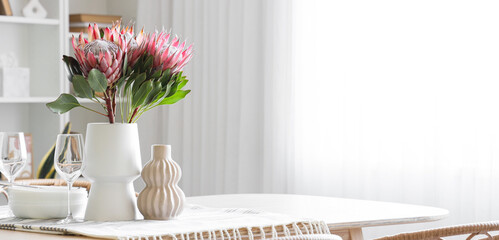 Table setting with protea flowers in dining room