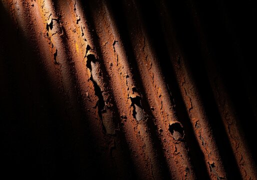 Dramatic low key close up of heavily rusted corrugated metal texture background