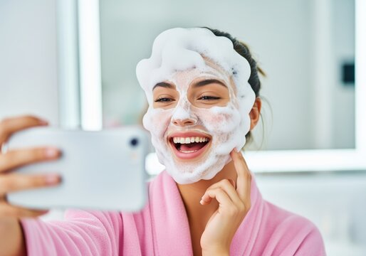 Cheerful woman taking a selfie with a foam face mask during her beauty routine
