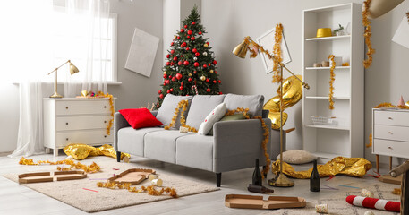 Interior of messy living room with sofa and tinsel after New Year party