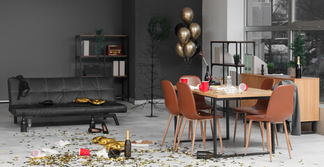 Interior of messy office with couch and table after New Year party
