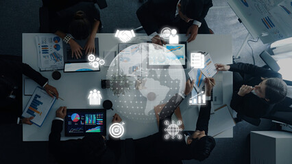 A group of professionals collaborates at a conference table, analyzing data and visualizations to drive strategic decisions in a dynamic business environment. Trope