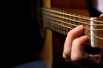 the hand clamps a chord on the guitar. playing a musical instrument. music education. lifestyle, A minor