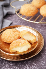 Plates with tasty choux dessert on grunge background