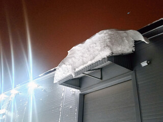 a snowdrift dangerously hanging from the roof. taken in winter