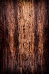 Naklejka premium background is made of old wood. an old board. the texture of a rustic table. Cocobolo, Dalbergia, red wood, a place for a text or object, frame, vignetting. the effect of aging, vertical