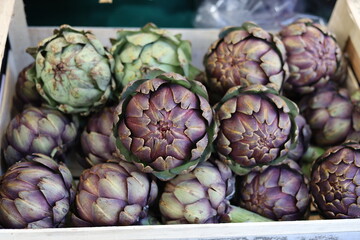 Fototapeta premium Fresh organic artichokes displayed for sale in produce market