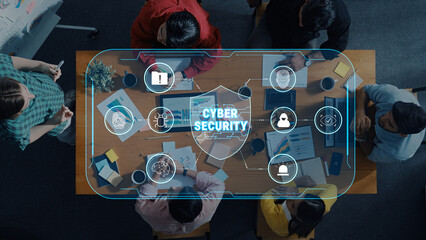 A top-down view of professionals discussing cyber security strategies, featuring a digital interface. The scene emphasizes teamwork and the importance of data protection. Trope