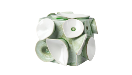 Green cube adorned with white petal-like shapes, creating abstract floral design on a black background