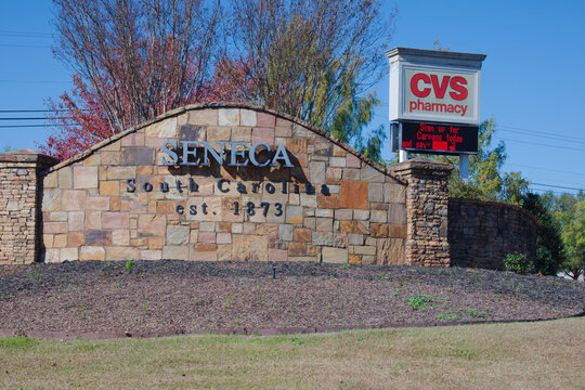 Seneca South Carolina Stone Entrance Sign With CVS Pharmacy Billboard, Established 1873. Editorial Use Only, November 3, 2025,Seneca South Carolina USA. A stone entrance sign Featuring the town name a