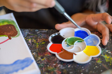 Artistic close-up of watercolor palette and brush in use, showing creativity, learning, and children art activities in vibrant colors