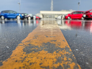 雨上がりの駐車場、濡れた地面と自動車