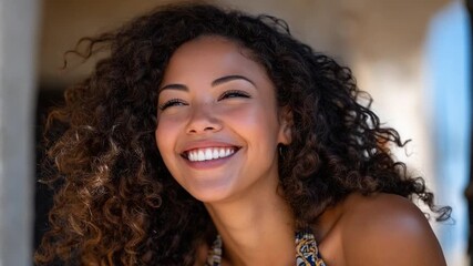 Radiant Joy: A portrait of a woman with curly hair, eyes closed, radiating pure happiness, capturing a moment of genuine smiles and positivity.