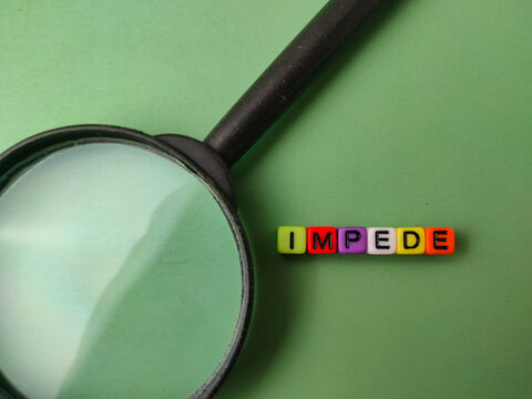 The image features a magnifying glass next to colorful letter beads that spell out the word IMPEDE