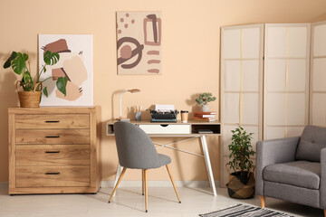 Stylish workspace with vintage typewriter, cup of coffee and books in living room