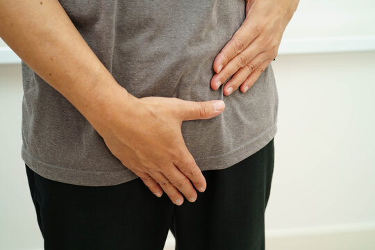 Hernia, Asian man stomach ache, abdominal pain and urology problem health.