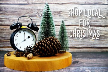 Festive holiday with Alarm clock, pinecones, and miniature Christmas trees on a wooden base with...