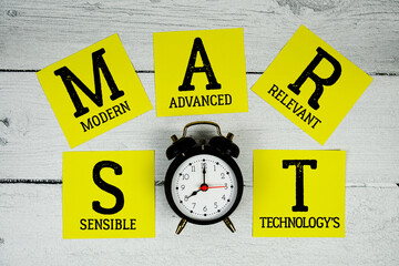 SMART Sensible Modern Advanced Relevant Technology's with alarm clock on wooden background