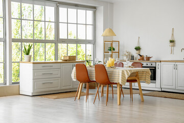 Served dining table with candles in kitchen