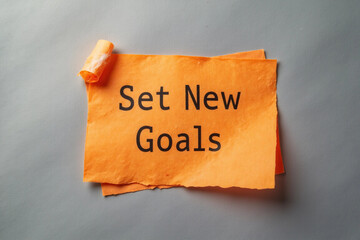 Set New Goals symbol. Concept words Set New Goals on orange steaky note. Beautiful grey background. Business and Set New Goals concept. Copy space. 3d rendering.