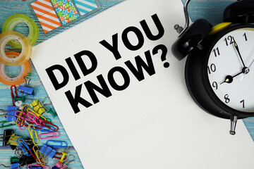 Did You Know? text with alarm clock and colorful office supplies on a blue wooden surface