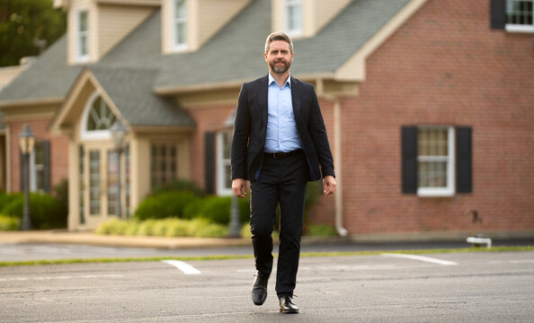 Real estate agent poses confidently in front of building ready for sale. Real estate entrepreneur closing deal. Real estate agent buying house. Realtor shows apartment. Real estate agent near building