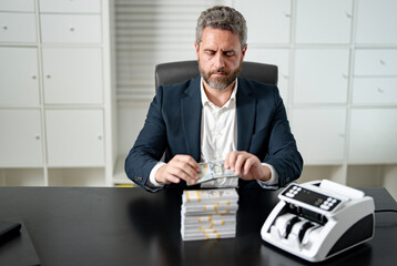 Businessman counting cash at his office desk. Office worker managing money at work. Accountant checking currency. Financial success. Banker organizing banknotes. Man counting money at office.